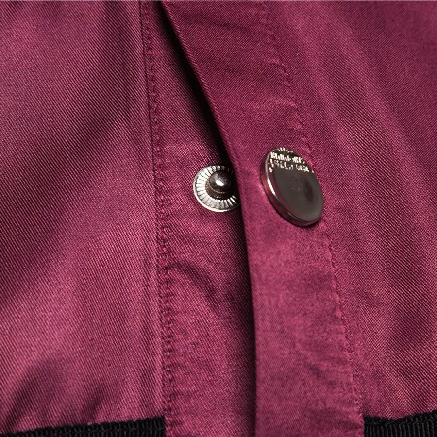 Close-up of the stylish rivets on a burgundy men's long sleeve shirt, showcasing quality casual fashion.
