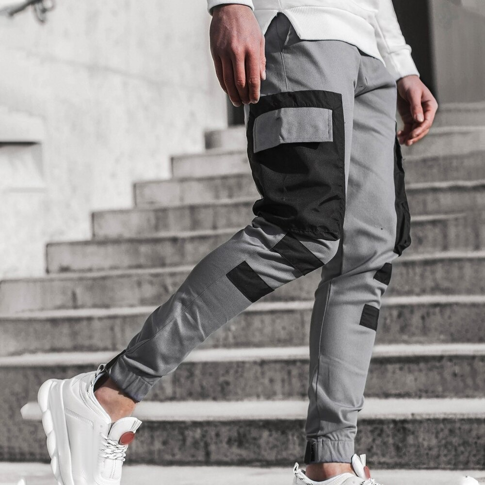 Fashion men's streetwear joggers pants in gray with black patch pockets, ideal for casual outings.