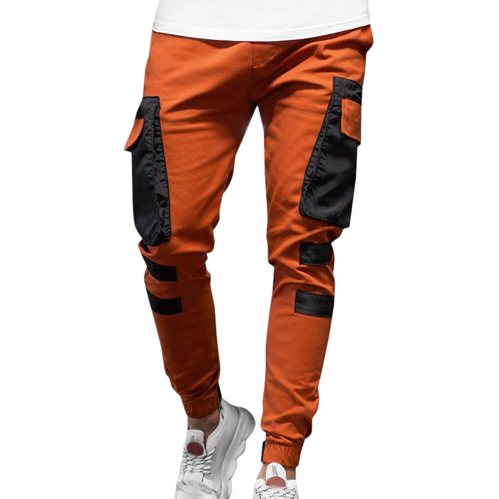 Men's streetwear joggers pants in orange with black patch pockets for casual sporty looks.