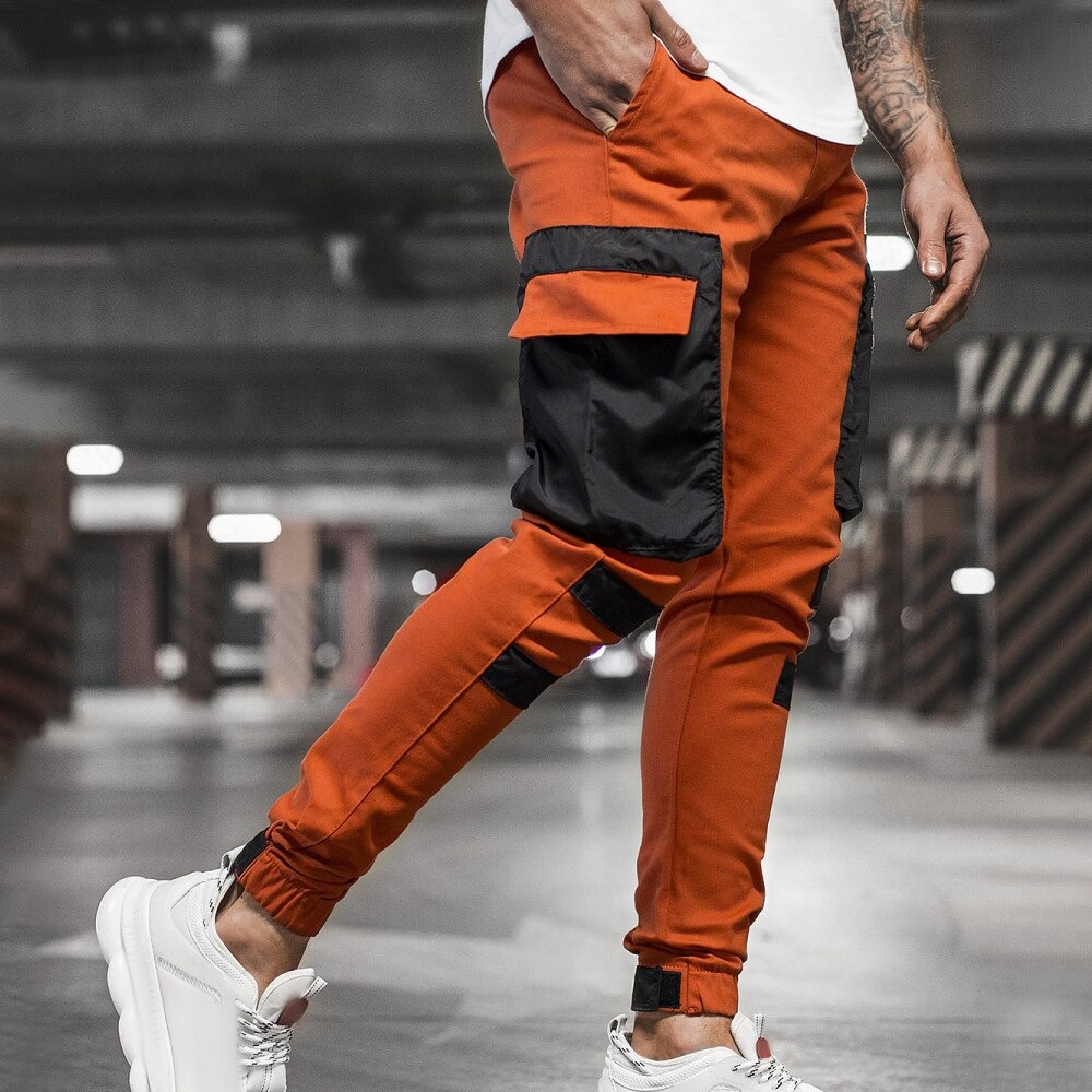 Men's trendy streetwear joggers pants with patch pockets in orange and black, perfect for casual sporty style.