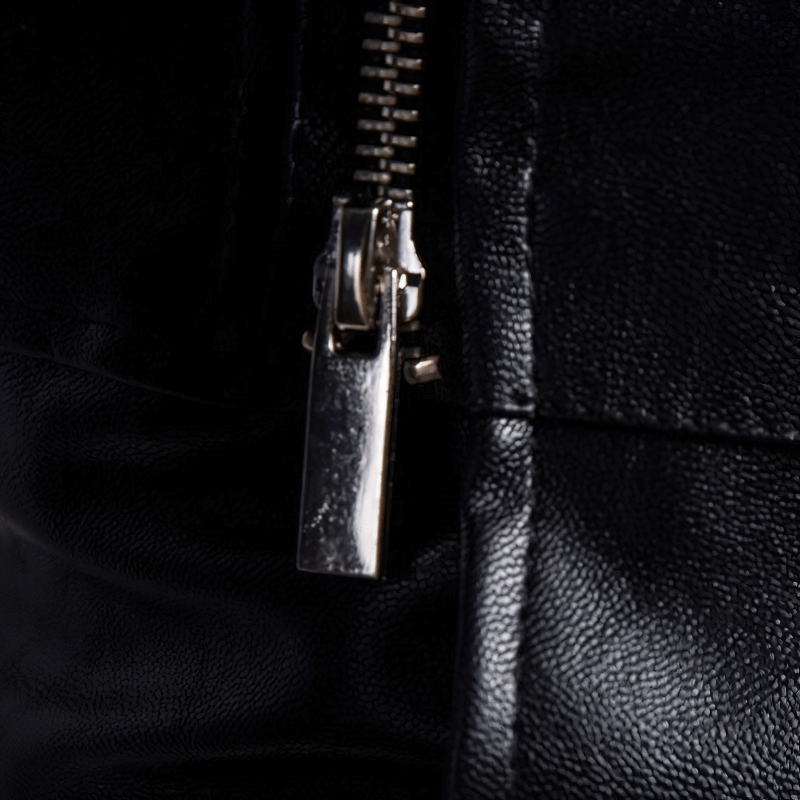 Close-up of zipper on men's black PU leather jacket, showcasing quality craftsmanship and style.