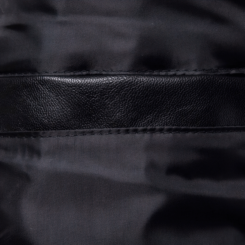 Close-up of the sleek black PU leather texture with a smooth stitching detail, showcasing quality craftsmanship.