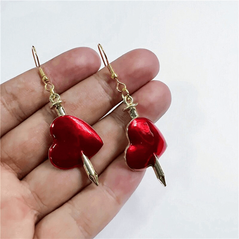 Gothic style red heart earrings with arrow design, perfect for enhancing any gothic outfit. Fashionable women's jewelry.