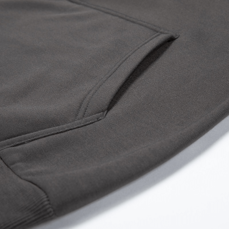 Close-up of a gray patchwork fleece hoodie pocket, showcasing its stylish design and comfort.