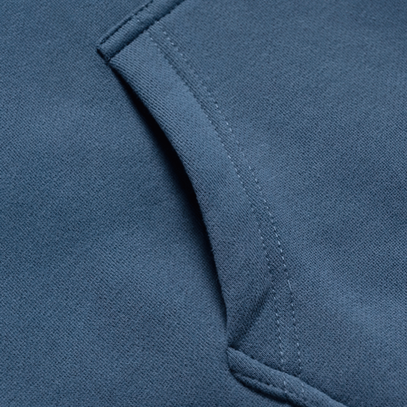 Close-up of a men's fleece patchwork hoodie pocket in a stylish blue color, showcasing its soft texture and craftsmanship.