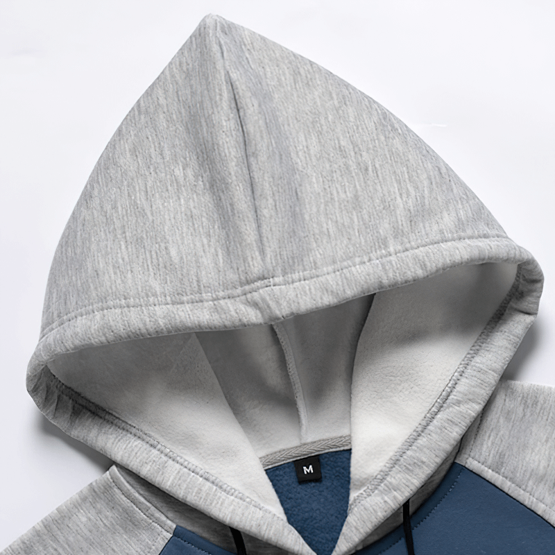 Close-up of a men's gray fleece hoodie hood showcasing cozy patchwork design for alternative fashion.