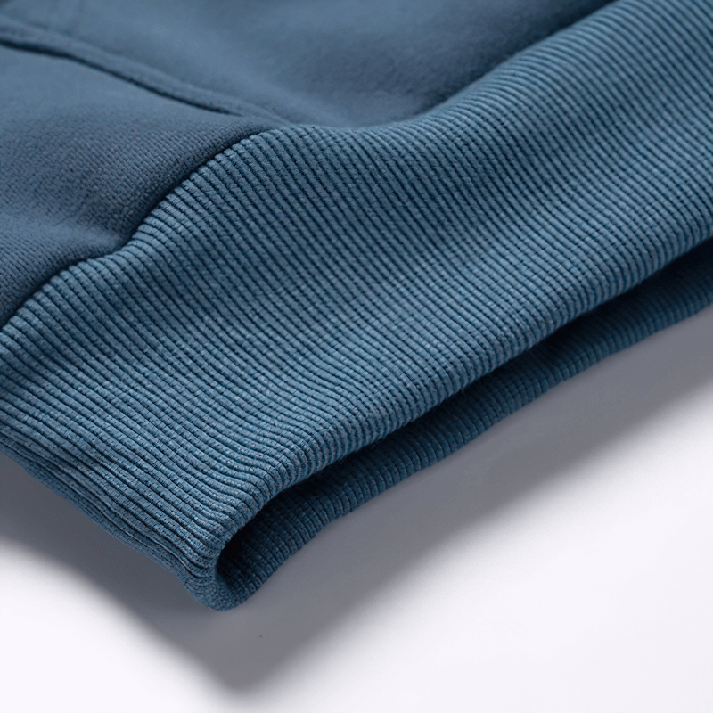 Close-up of the ribbed cuff of a blue fleece hoodie, showcasing its texture and comfortable design.