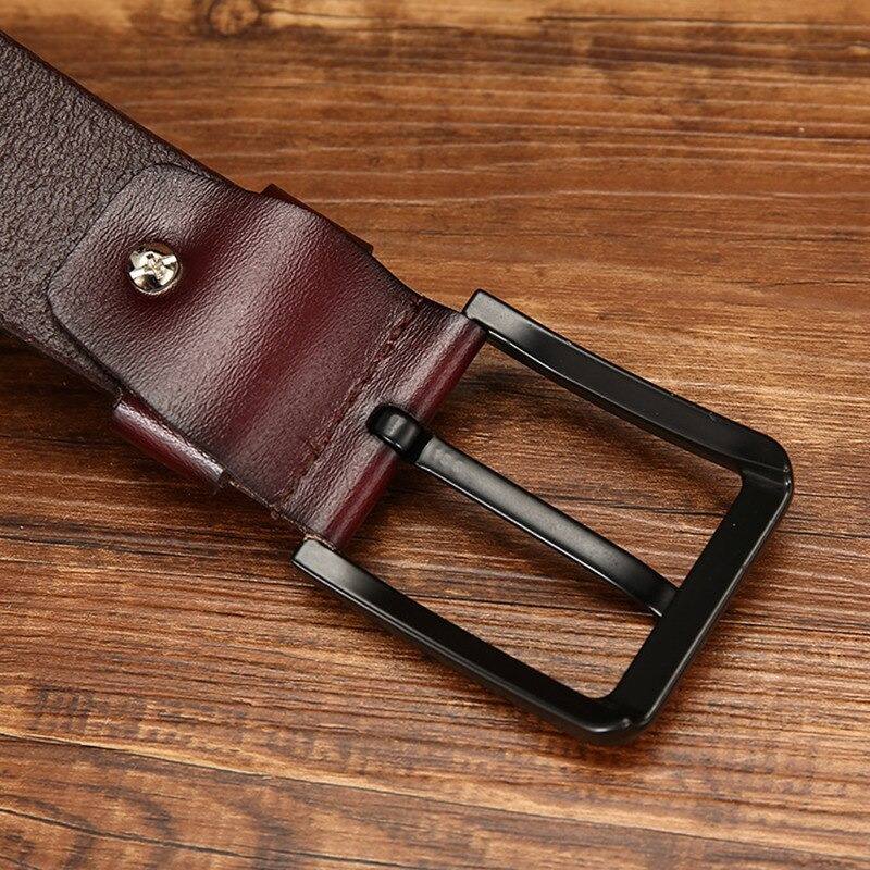 Close-up of a fashionable PU leather belt with a stylish black buckle against a wooden background.