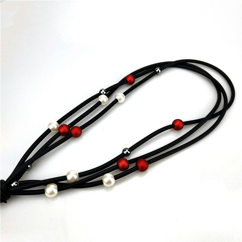 Red and white pearls long necklace on black rubber, perfect luxury accessory for casual outfits.