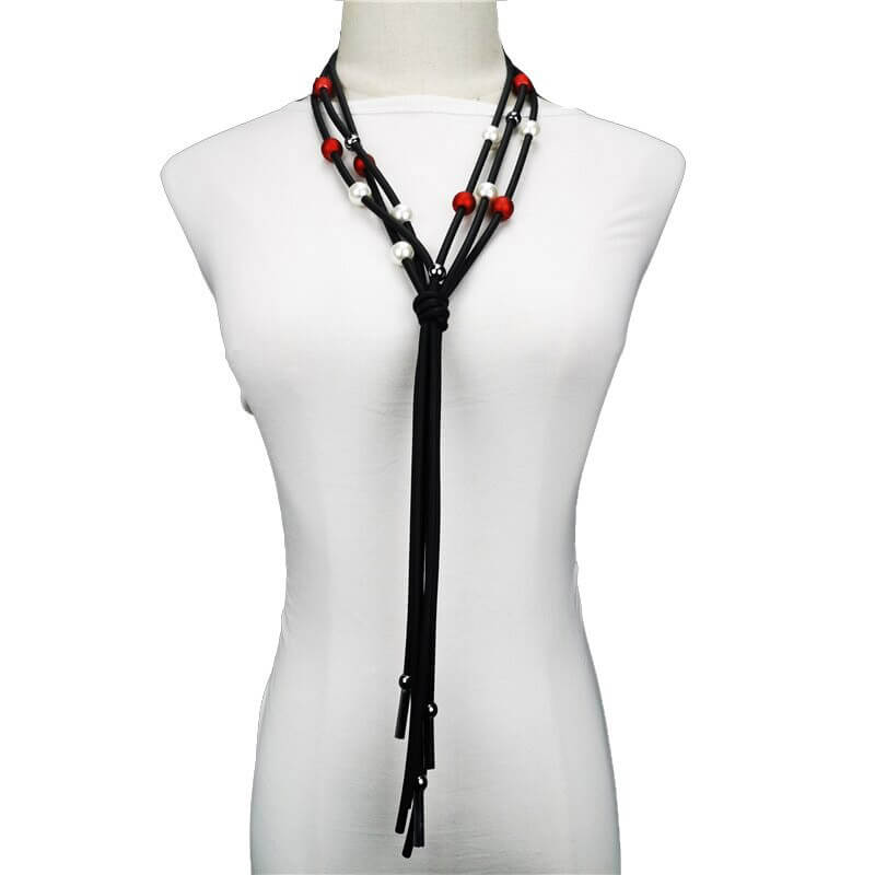 Elegant long necklace with red and white pearls on a mannequin, perfect for casual luxury jewelry styling.