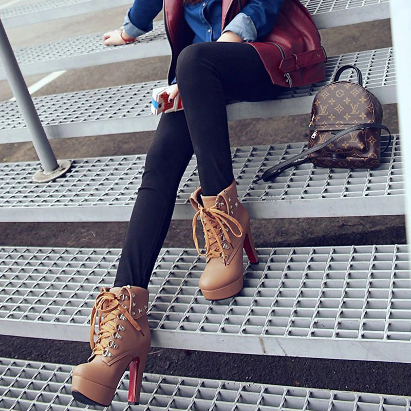 Trendy women's PU leather ankle boots with thick high heels and lace-up design, paired with stylish handbag and black jeans.