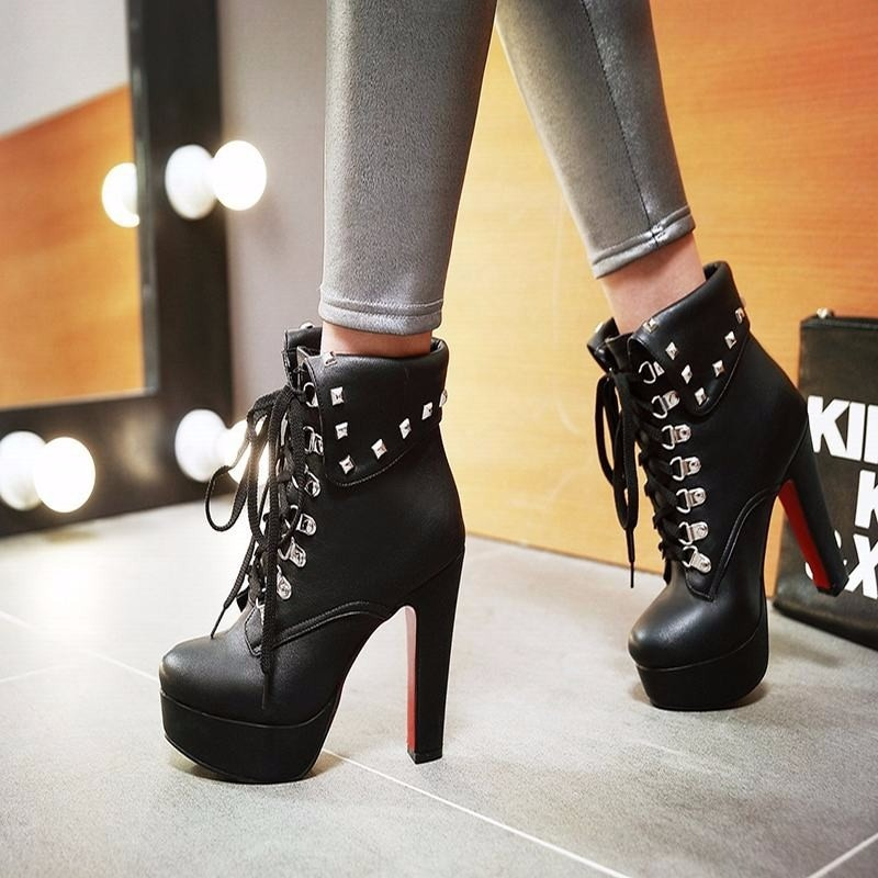 Stylish women's black lace-up ankle boots with thick heels and silver rivets in a trendy punk design.