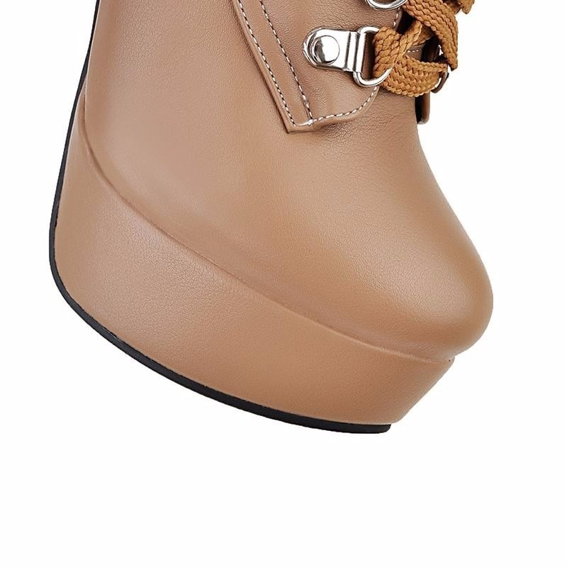Close-up of stylish women's ankle boot with thick heel, lace-up detail, and shiny PU leather in tan color.