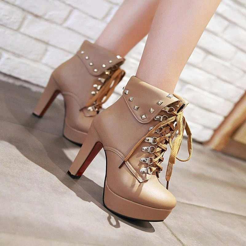 Women's faux leather lace-up ankle boots with thick heels and silver rivets, perfect for a modern punk look.