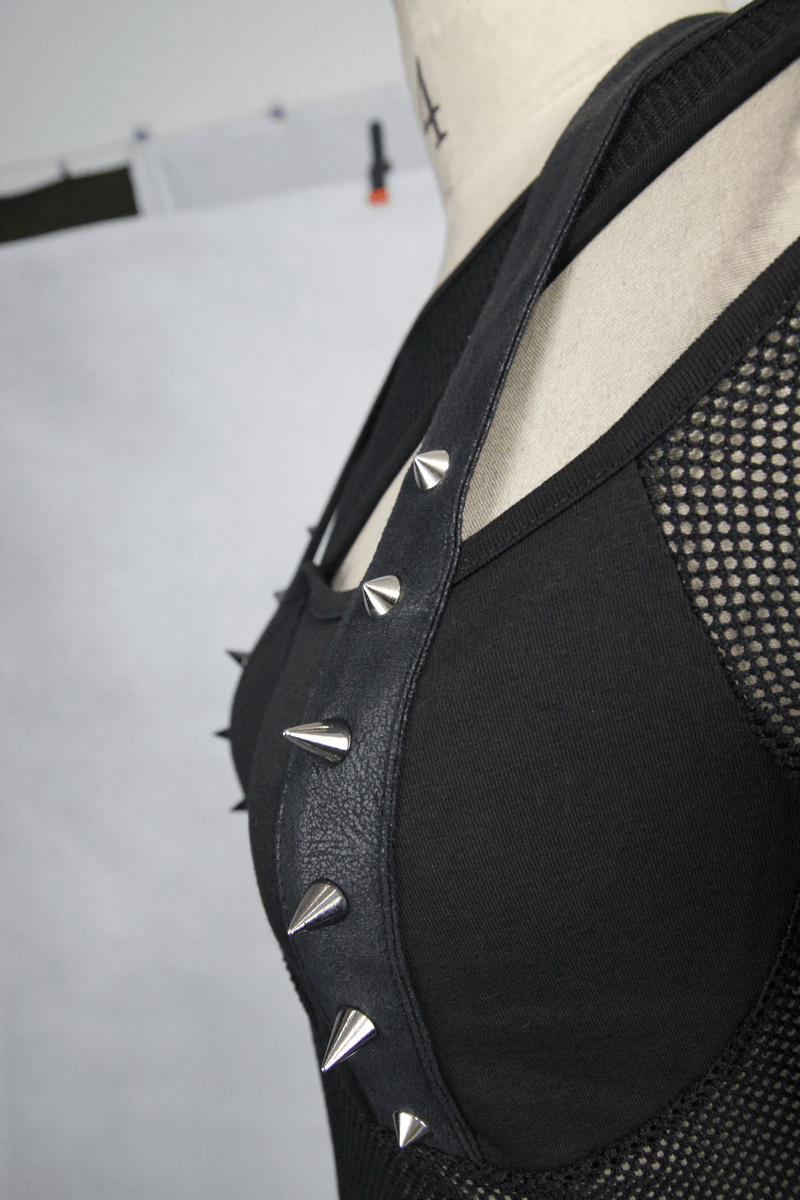 Close-up of women’s black mesh top with PU leather spikes, showcasing gothic style and slim fit.
