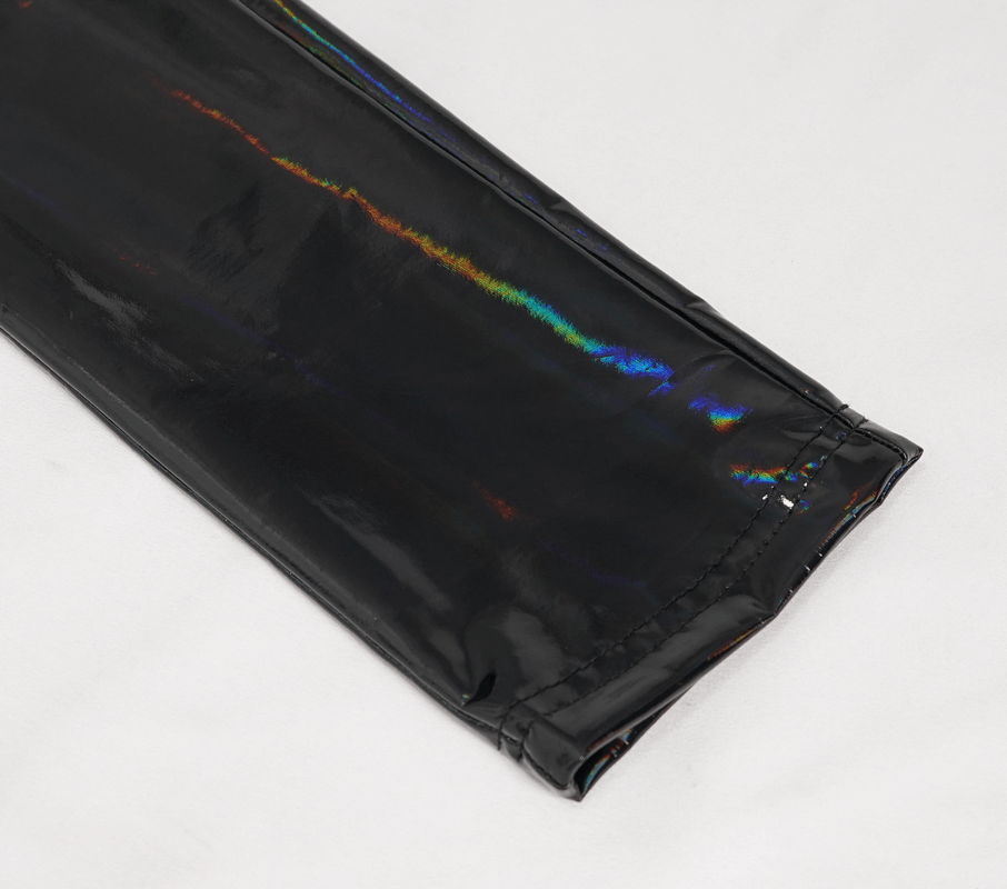 Close-up of black slim PU leather pants showing shiny wetlook finish and detailed stitching for women's fashion.