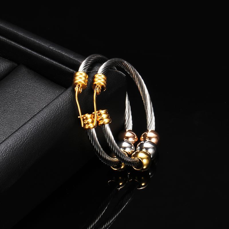 Fashionable stainless steel earrings in silver with gold accents, showcasing elegant design and trendy style for women.