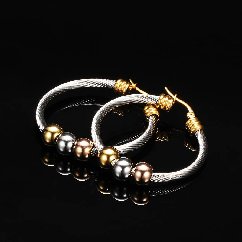 Elegant stainless steel earrings with twisted design and shiny beads in gold, silver, and bronze, perfect for any outfit.