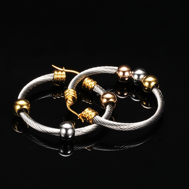 Elegant stainless steel earrings in silver with twisted design and shiny gold and rose accents.