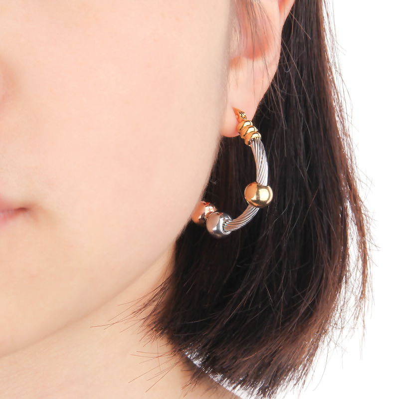 Stainless steel earrings in silver and gold, featuring a twisted design and decorative beads, perfect for elegant women's fashion.