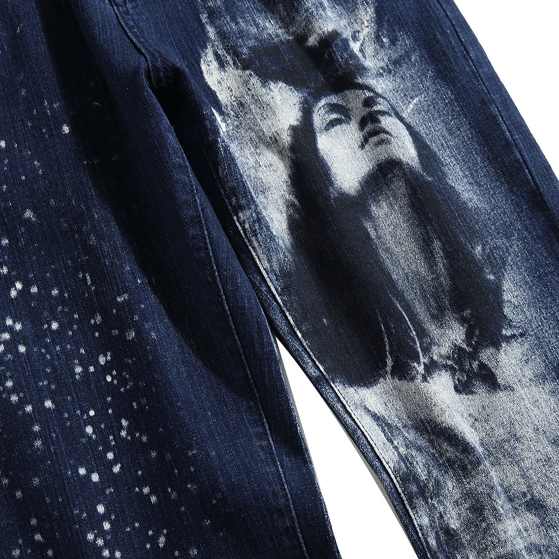 Close-up of trendy denim jeans with artistic 3D print featuring a mysterious woman's face and celestial patterns.