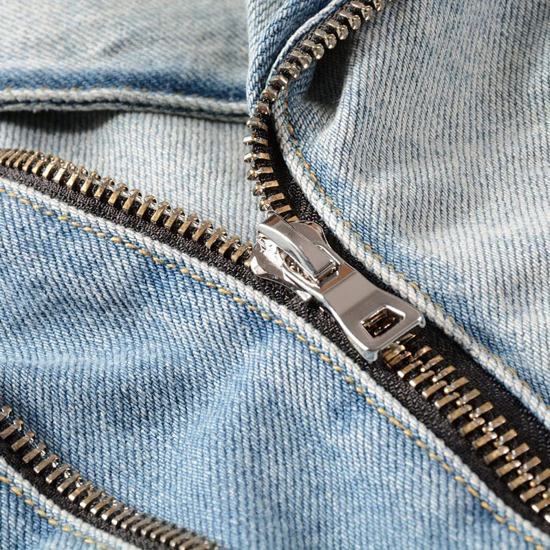 Close-up of a stylish denim jacket zipper, showcasing rock-inspired fashion details and alternative style.