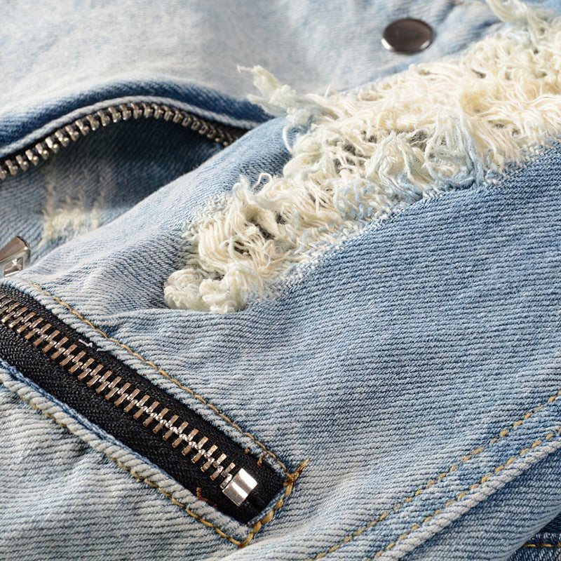 Close-up of denim jacket detailing, featuring zippers and stylish distressed fabric for a rock-inspired look.