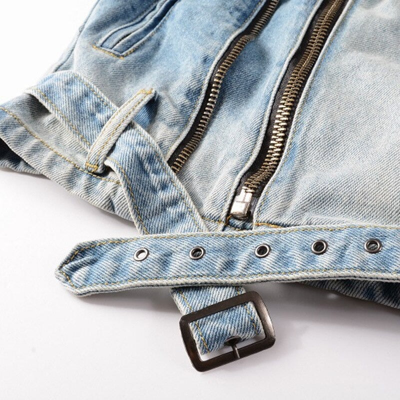 Close-up of denim jacket showing zippers and adjustable straps, highlighting its rock-style fashion.
