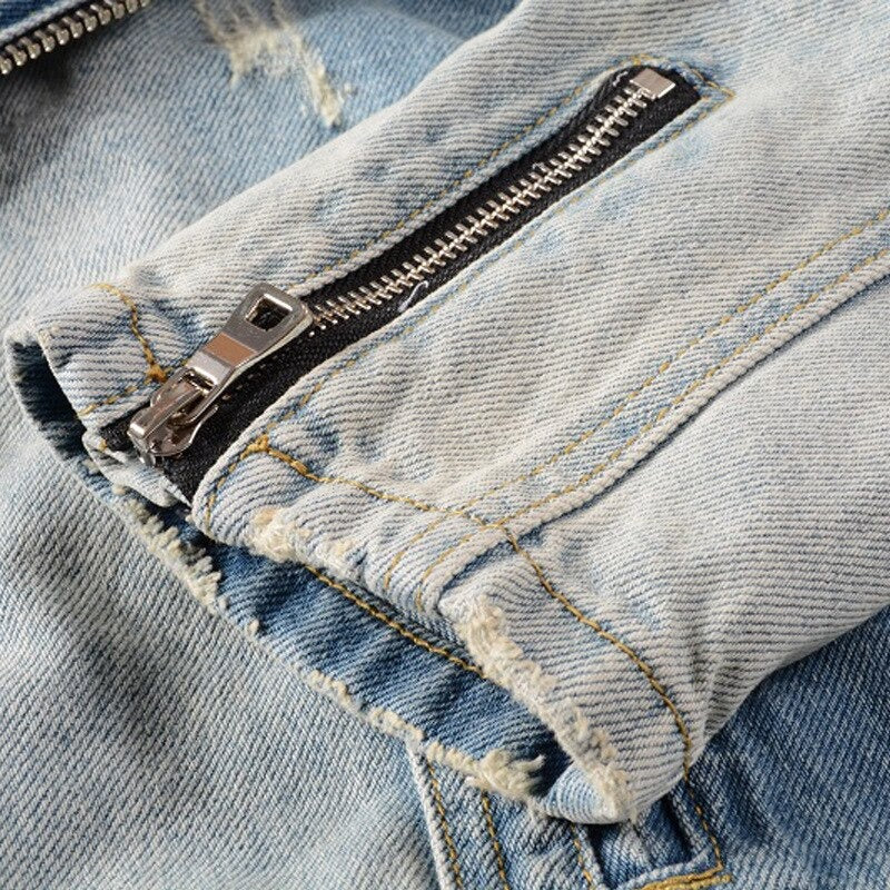 Close-up of the denim jacket's zipper detail in light blue, showcasing rock style with frayed edges and trendy design.