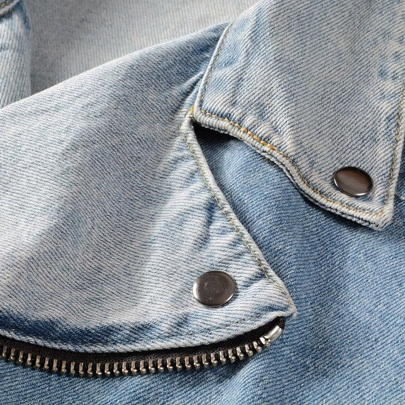 Close-up of light blue fashion denim jacket collar with zippers and buttons, ideal for rock style enthusiasts.