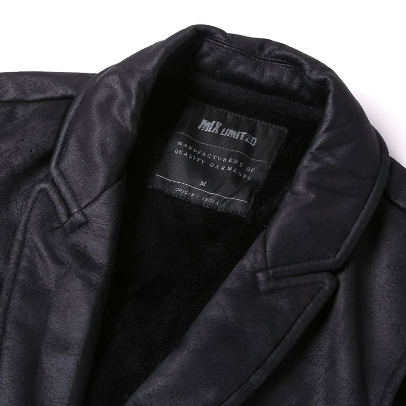 Close-up of a black suede vest collar with the MIK Limited label, showcasing high-quality craftsmanship.