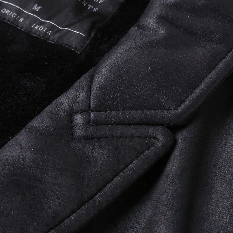 Close-up of the stylish stitching detail on a black suede vest, showcasing its luxurious fabric and quality craftsmanship.