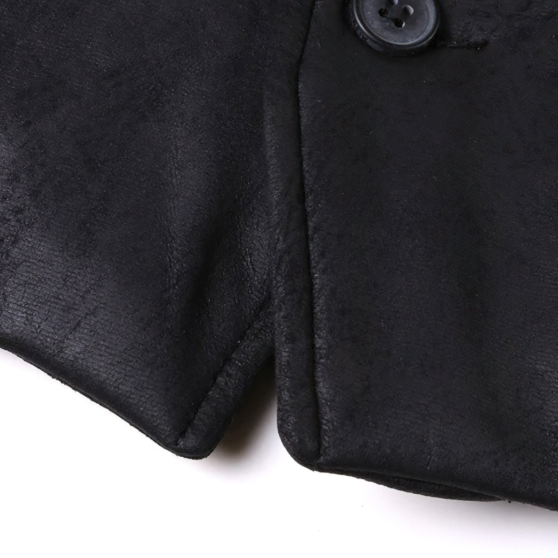 Close-up of black suede men’s vest showing detailed stitching and button design in steampunk style.