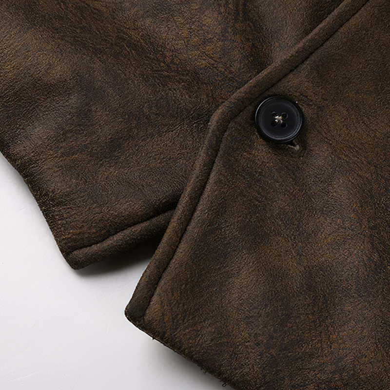 Close-up of brown suede fabric and button on a stylish steampunk vest for men.