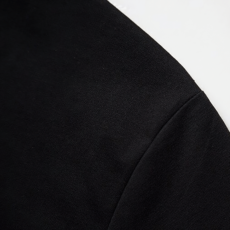 Close-up of the sleeve of a black casual t-shirt, showcasing its smooth fabric and alternative style.