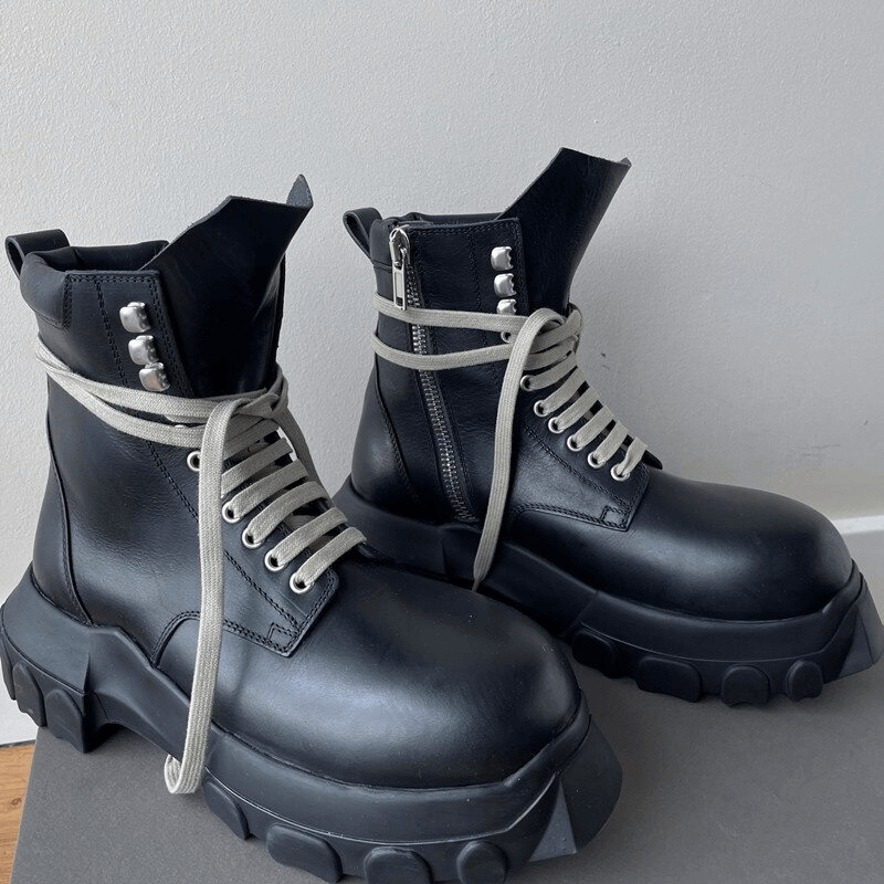 Stylish thick-sole black ankle boots with light-colored laces and rivets, perfect for casual outfits.