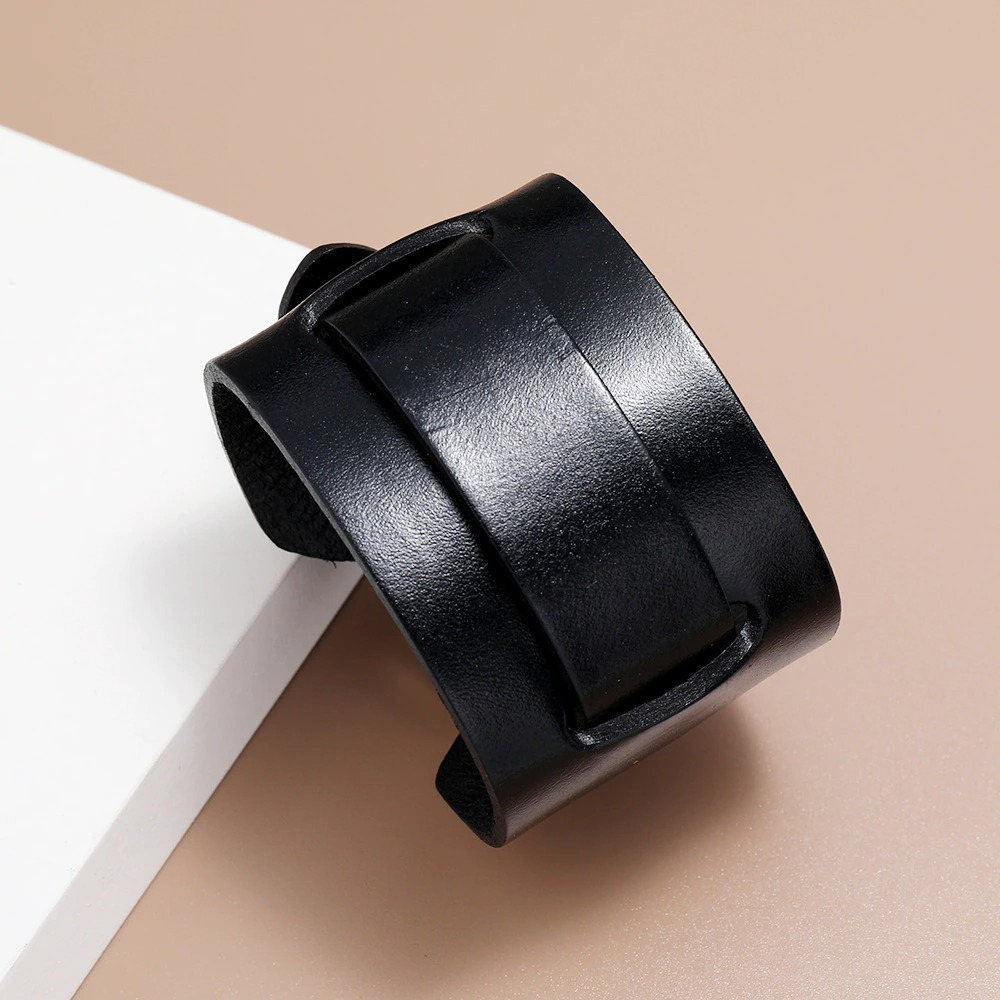 Fashionable black wide genuine leather bracelet on a neutral background, perfect for a trendy vintage style.
