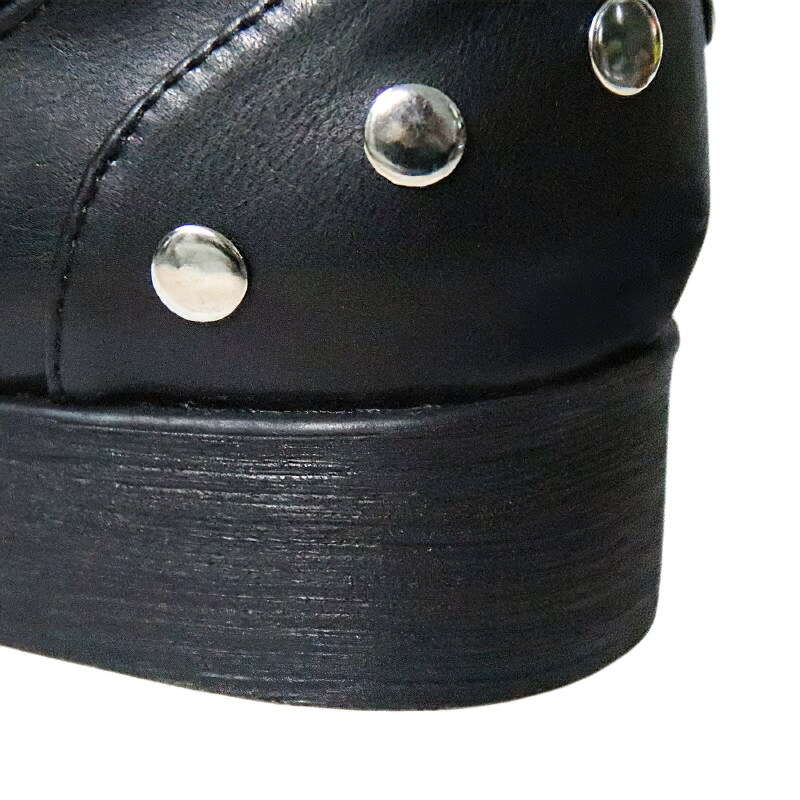 Close-up of trendy women's ankle boots with silver rivets and low heel, made from quality PU leather.