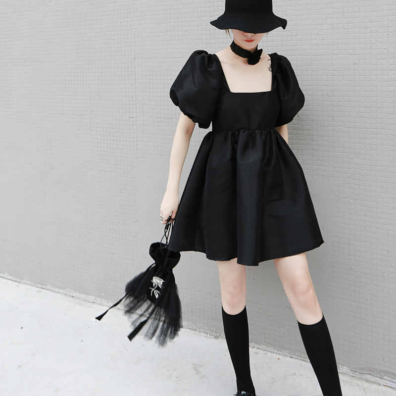 Fashion women's black mini dress with short puffy sleeves and square neckline, styled with a gothic hat and accessories.