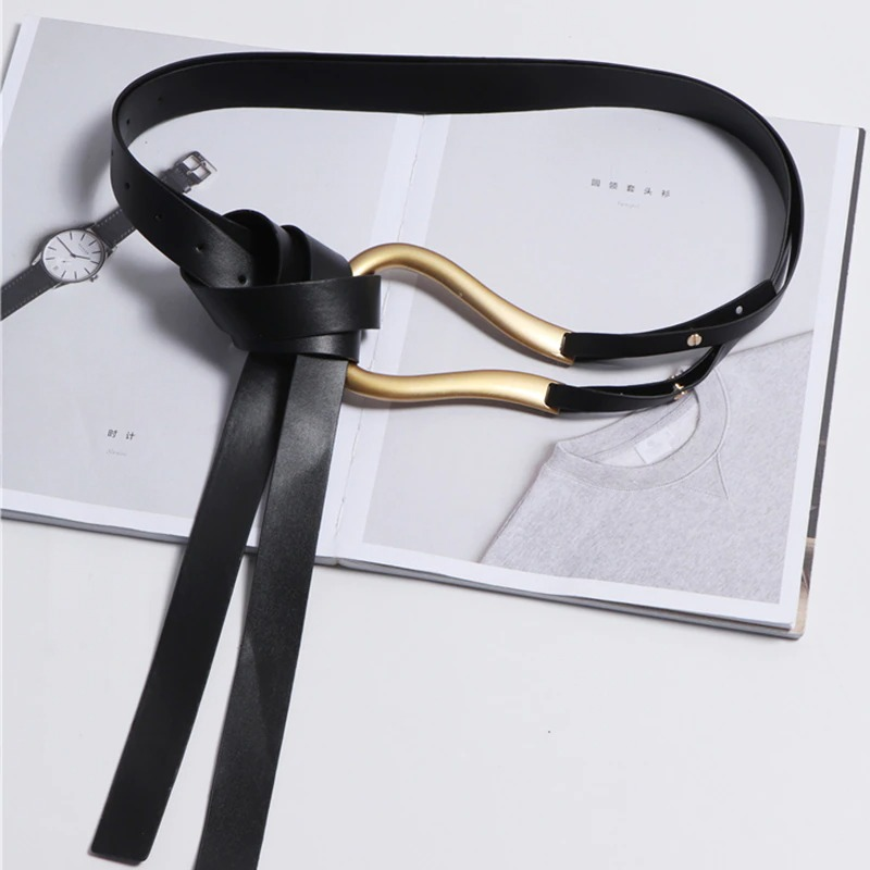 Trendy black PU leather belt with gold buckle styled on open magazine, perfect accessory for any outfit.