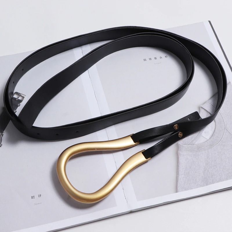 Fashion women's PU leather belt with a stylish gold buckle on a magazine backdrop.