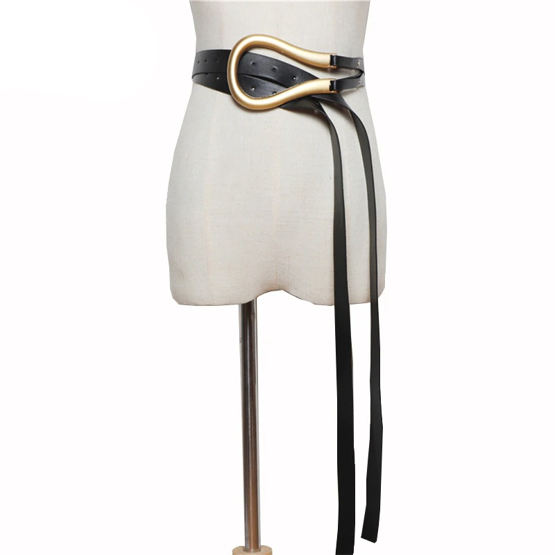Trendy black PU leather belt with a gold buckle on a dress form, perfect for stylish outfits.