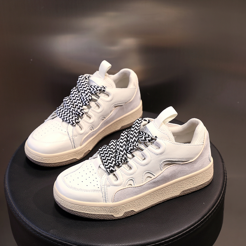 Fashion Women's Chunky Platform Sneakers with black and white patterned laces on a round display.