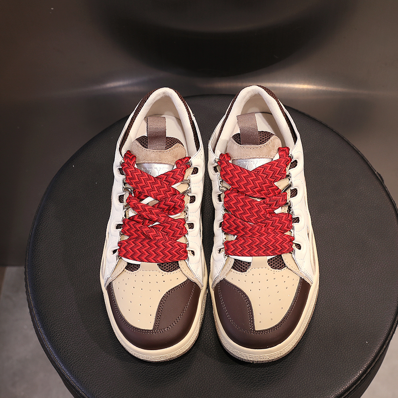 Fashion women's chunky platform sneakers in cream and brown with bold red woven laces on a black round seat.
