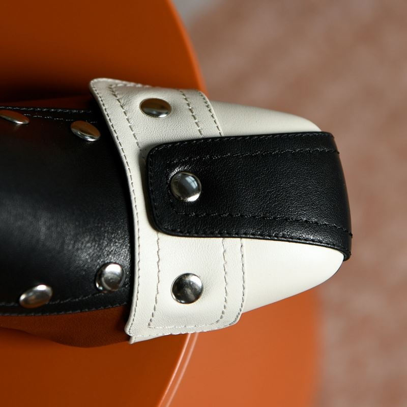 Close-up of stylish women's leather boot featuring black and white design with rivets, perfect for trendy casual looks.