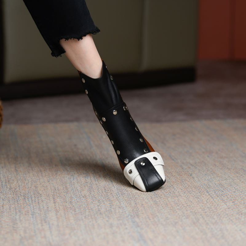 Casual women's high heel ankle boots with rivets in black and white, showcasing genuine leather design and trendy style.