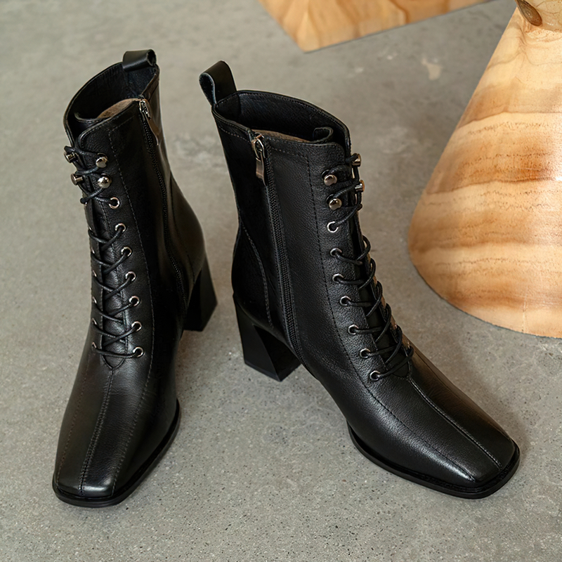 Stylish women's black genuine leather ankle boots with lace-up and zip detail, perfect for casual chic outfits.