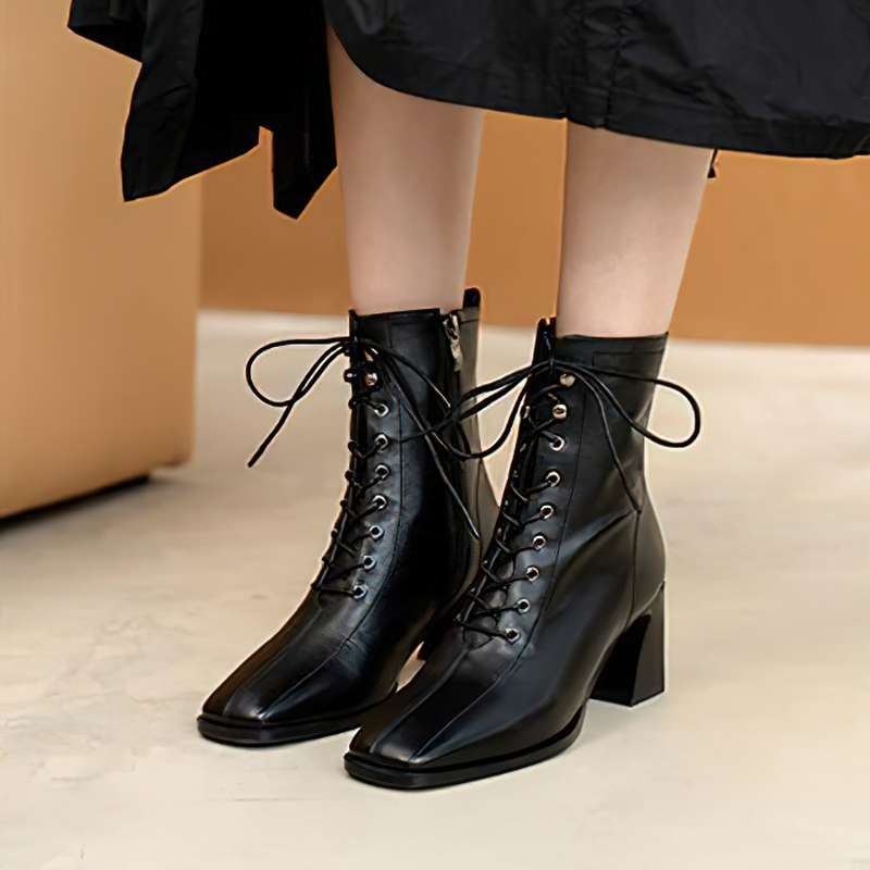 Fashionable women's black leather ankle boots with a block heel and lace-up design, perfect for casual stylish looks.