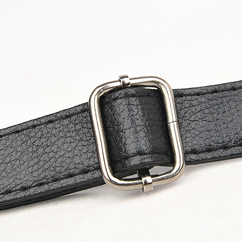 Close-up of a stylish black handbag strap with a silver metal buckle, showcasing quality PU leather texture.