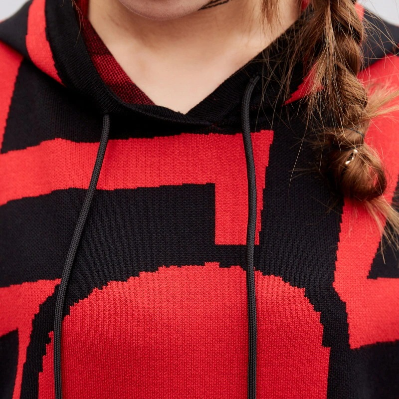 Close-up of a women's oversized hoodie with vibrant red and black skull print, highlighting its cozy knit texture.